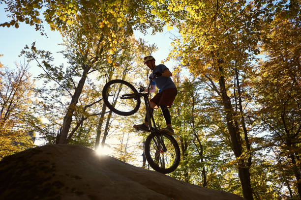 istock Sportsman cyclist balancing on back wheel on trial bicycle 1127160669