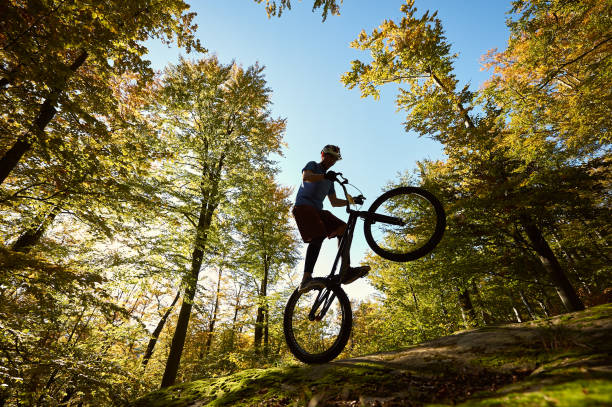 istock Sportsman cyclist balancing on back wheel on trial bicycle 1127160670