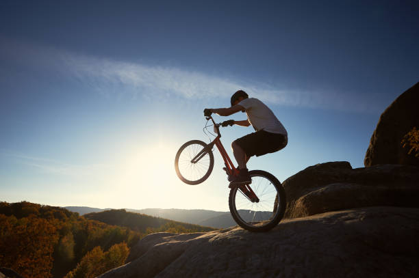 Young man jumping and riding on a BMX bicycle.