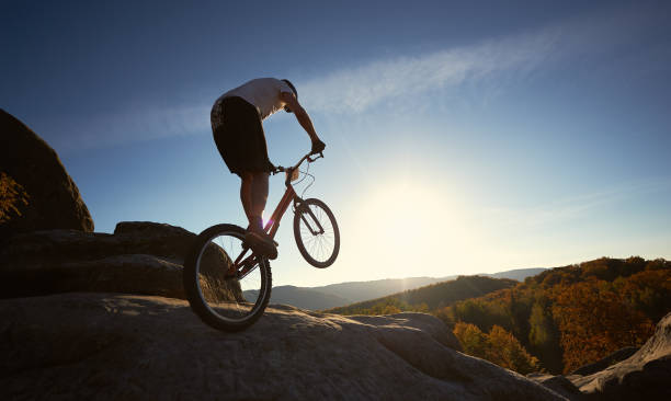 istock Sportsman cyclist balancing on back wheel on trial bicycle 1127160676