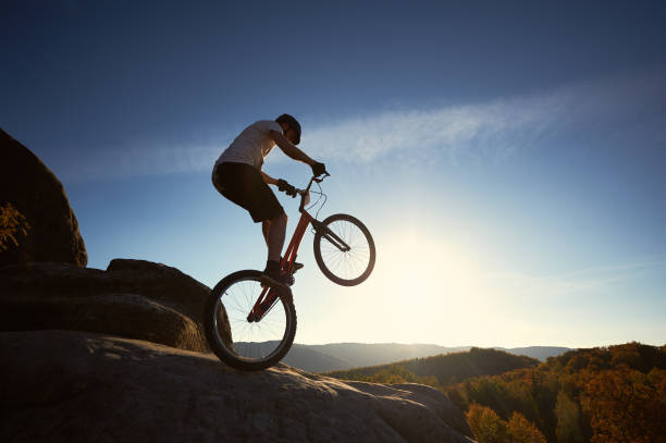 istock Sportsman cyclist balancing on back wheel on trial bicycle 1127160678