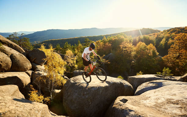 istock Sportsman cyclist balancing on back wheel on trial bicycle 1127160689