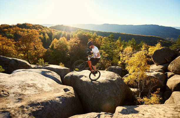 istock Sportsman cyclist balancing on back wheel on trial bicycle 1127160690