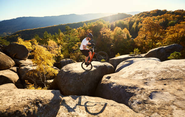 istock Sportsman cyclist balancing on back wheel on trial bicycle 1127160692