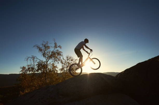 istock Sportsman cyclist balancing on back wheel on trial bicycle 1127160713