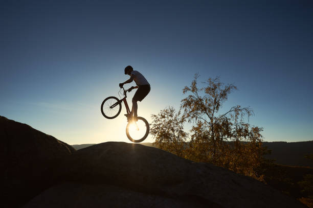 istock Sportsman cyclist balancing on back wheel on trial bicycle 1127160717