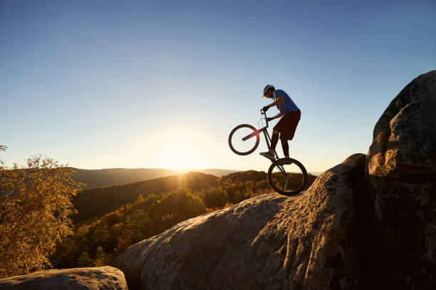 istock Sportsman cyclist balancing on back wheel on trial bicycle 1127160746