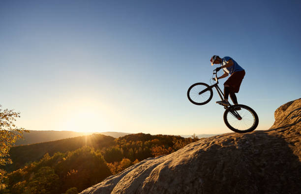 istock Sportsman cyclist balancing on back wheel on trial bicycle 1127160748