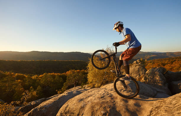 istock Sportsman cyclist balancing on back wheel on trial bicycle 1127160946