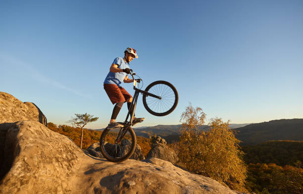 istock Sportsman cyclist balancing on back wheel on trial bicycle 1127160948