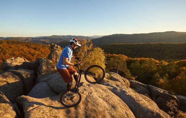 istock Sportsman cyclist balancing on back wheel on trial bicycle 1127160951