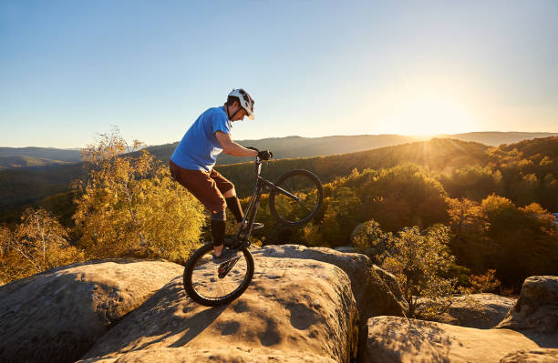 istock Sportsman cyclist balancing on back wheel on trial bicycle 1127160953