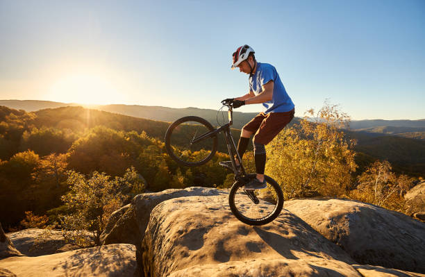 istock Sportsman cyclist balancing on back wheel on trial bicycle 1127160956