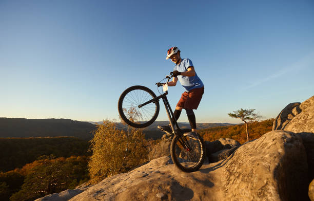 istock Sportsman cyclist balancing on back wheel on trial bicycle 1127160961