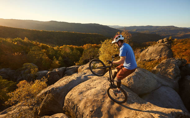 istock Sportsman cyclist balancing on back wheel on trial bicycle 1127160962