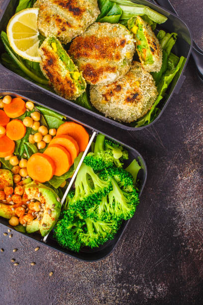 Healthy meal prep containers with green burgers, broccoli, chickpeas and salad. Healthy meal prep containers with green burgers, broccoli, chickpeas and salad on dark background. food state stock pictures, royalty-free photos & images