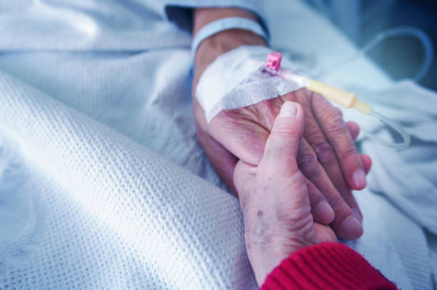 istock Wife holding sick husband's hand in hospital 1127166849