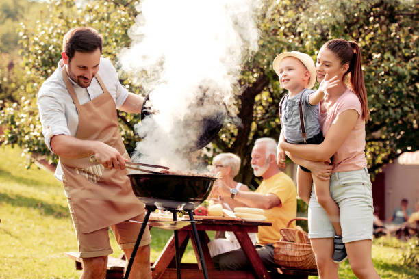 family having a barbecue party in their garden - picnic family barbecue social gathering imagens e fotografias de stock