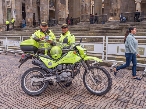 Bogota, Colombia - September 13, 2013: A policemen with motor in yellow uniform in front of National Capitol. Bolivar Square, La Candelaria.