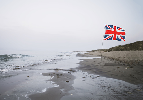 United Kingdom Flag blowing in a strong breeze in a clear blue sky