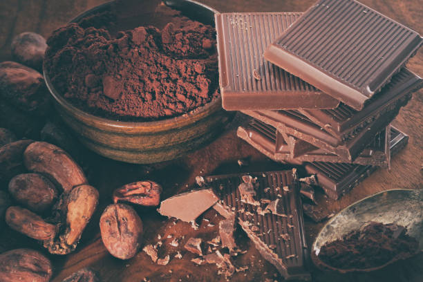 istock Broken dark chocolate, cocoa powder and coffee beans on a wooden table 1127173885
