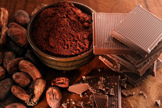 istock Broken dark chocolate, cocoa powder and coffee beans on a wooden table 1127173898