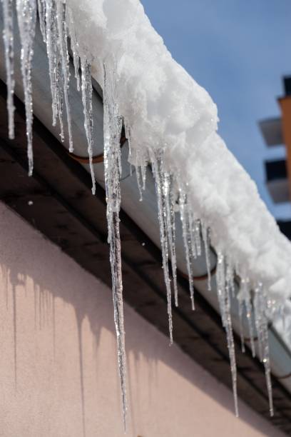 istock Icicles hanging from roof covered by snow in winter. 1127176566