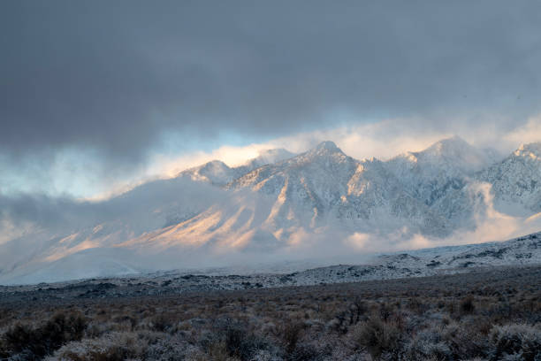 istock morning sunlight and clouds over fresh desert snowfall and snowy mountain peaks 1127188163