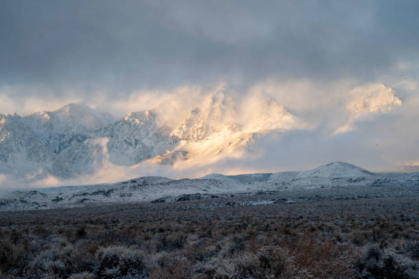 istock morning sunlight and clouds over fresh desert snowfall and snowy mountain peaks 1127188165