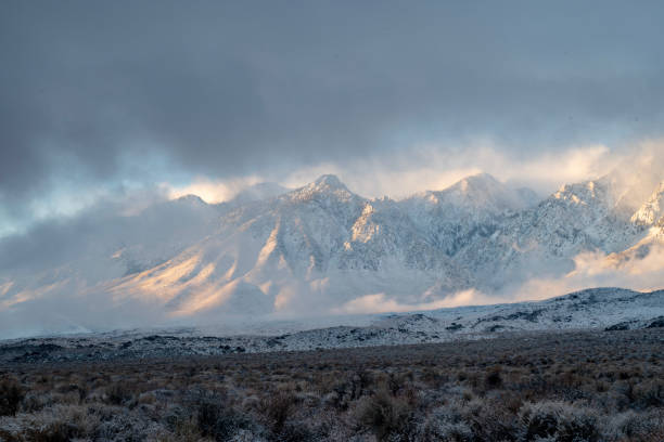 istock morning sunlight and clouds over fresh desert snowfall and snowy mountain peaks 1127188240