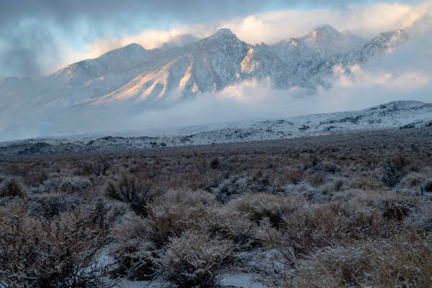 istock morning sunlight and clouds over fresh desert snowfall and snowy mountain peaks 1127188258