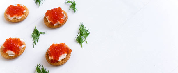 istock Basis for a banner with sandwiches with red caviar. Salmon caviar for print design, web site, banner, flyer. Appetizer with red caviar 1127191821