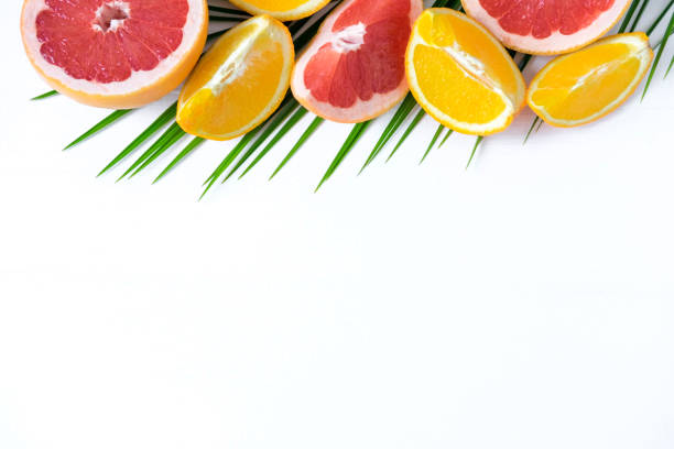 istock The basis for the banner with palm leaf and fruit. Grepfruit, orange, palm leaf with space for copispeysa. Frame for text with leaf of palm tree and fruit on a wooden background 1127191873
