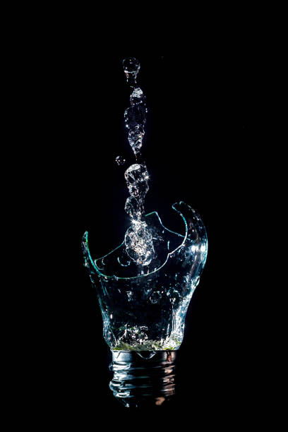 istock Creative broken light bulb with water fountain on isolated black background with flash 1127195611