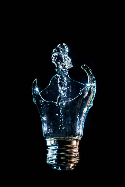 istock Creative broken light bulb with water fountain on isolated black background with flash 1127195613