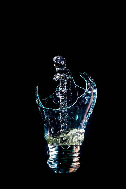 istock Creative broken light bulb with water fountain on isolated black background with flash 1127195638