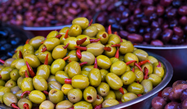 istock Green olive stuffed with red pepper close-up. Fruit and vegetable market. Selective focus 1127202490