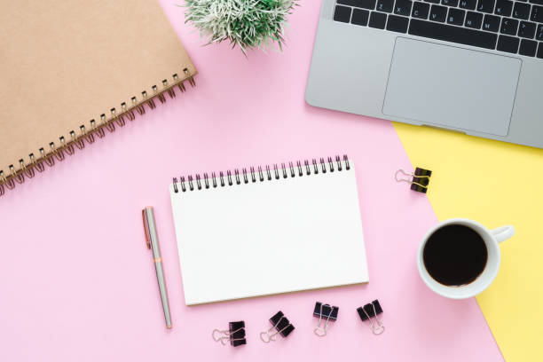 istock Creative flat lay photo of workspace desk. Top view office desk with laptop, blank empty notebooks and coffee cup on pastel color background. Top view with copy space, flat lay photography. 1127202685