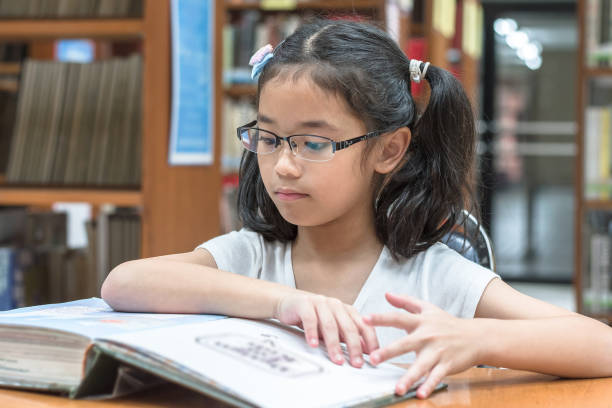 istock School education and literacy concept with Asian girl kid student learning and reading book in library or classroom 1127204377