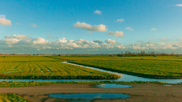 View of fields under sky and clouds in the dutch countryside near Rotterdam, the Netherlands