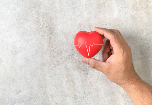 istock Man holding a red heart shape on marble table 1127210080
