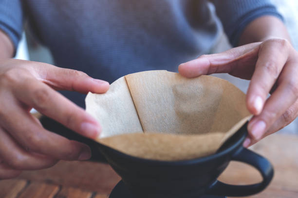 a woman's hands setting a filter to make a drip coffee
