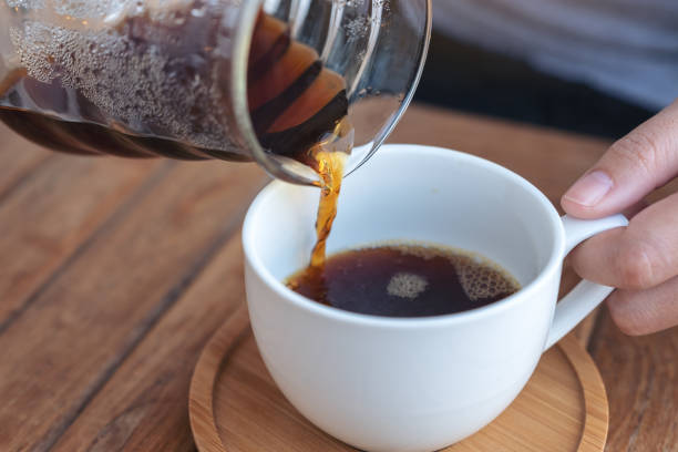 istock a hand pouring drip coffee into a white mug 1127219641