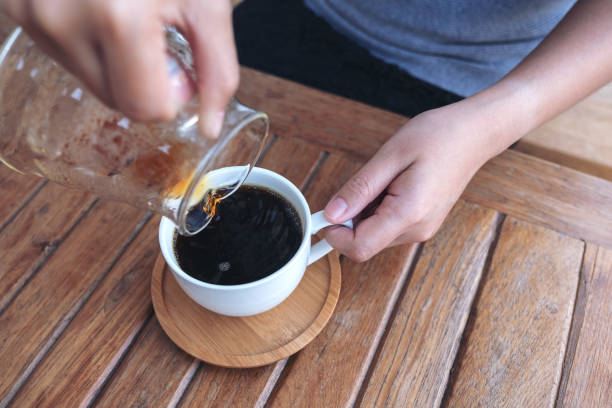 istock a hand pouring drip coffee into a white mug 1127219647