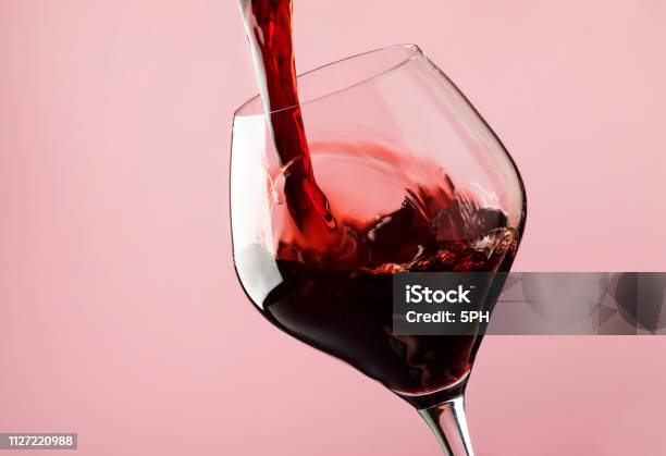 フランス辛口の赤ワイングラストレンディなピンクの背景に注ぐ - ワインのストックフォトや画像を多数ご用意 - ワイン, ワインレッド, 赤ワイン