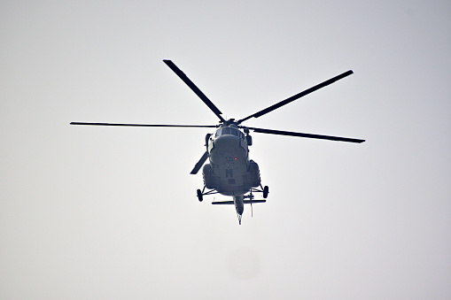 Helicopter is flying against isolated on grey background