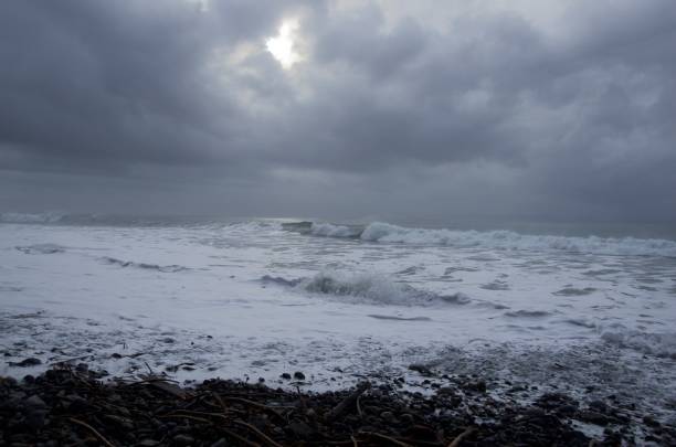 istock Waves crash onto China Beach creating white foam, dramatic clouds overhead 1127236916