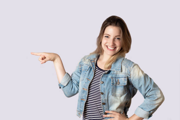 istock Young woman pointing away 1127239782
