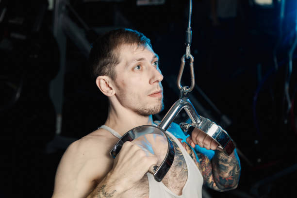 istock Handsome athletic man working out on the gym machine in the gym 1127244344