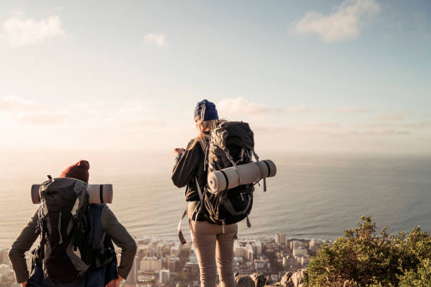 istock Rear view of backpackers over looking cityscape and sea 1127244527